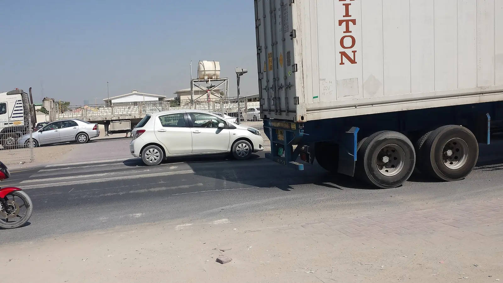 Articulated truck and parked cars on a service road in Al Quoz, Dubai